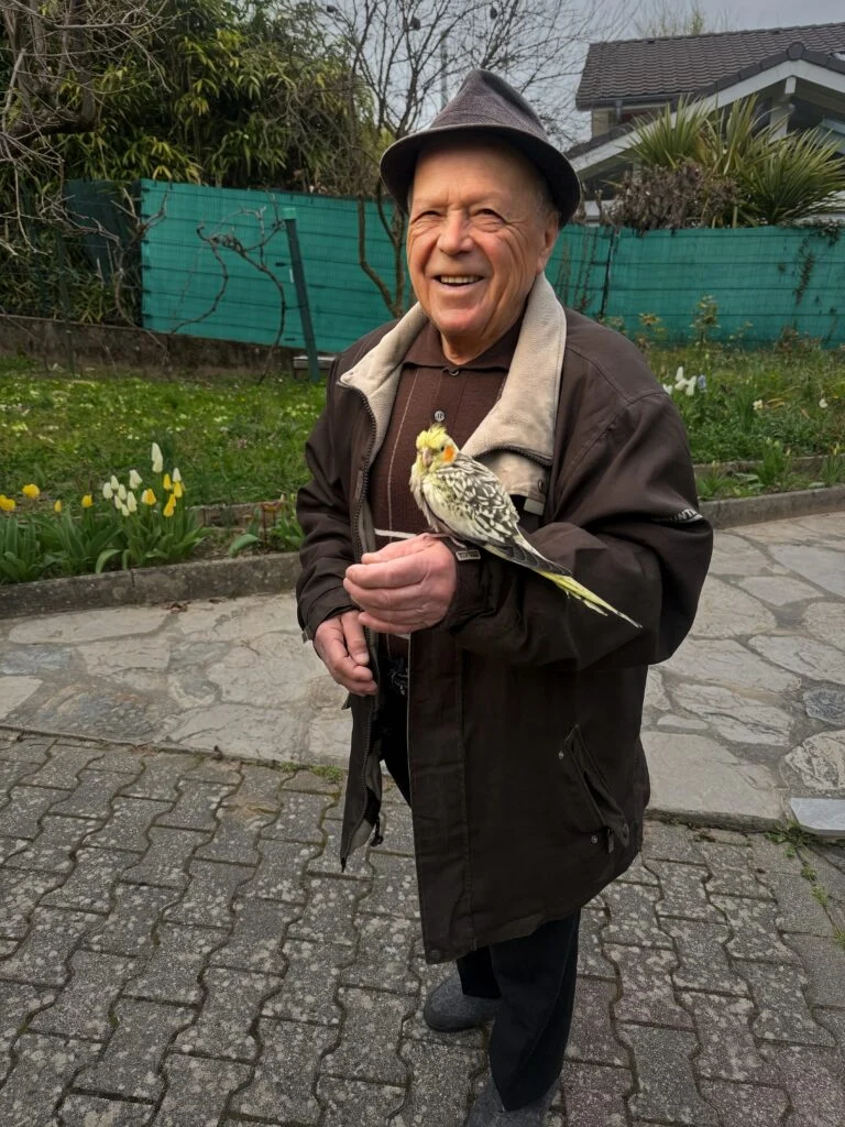 Personne âgée avec un oiseau posé sur la main