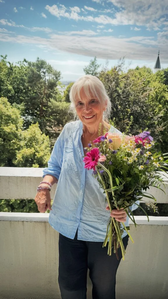 Personne âgée souriante avec un bouquet de fleurs